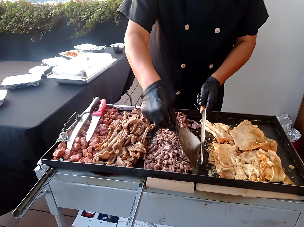 Cocinero asando carnes en la parrilla